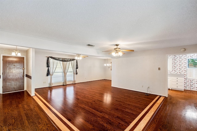 unfurnished living room with baseboards, visible vents, wood finished floors, a textured ceiling, and ceiling fan with notable chandelier