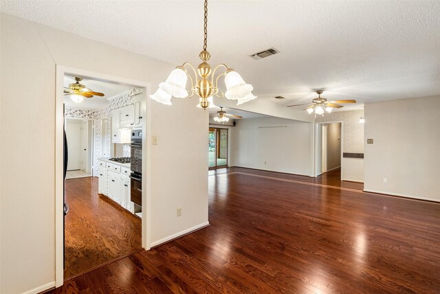 interior space featuring ceiling fan with notable chandelier, hardwood / wood-style flooring, and a textured ceiling