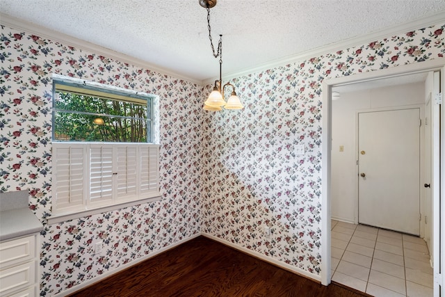 dining area featuring hardwood / wood-style flooring, a textured ceiling, and ornamental molding