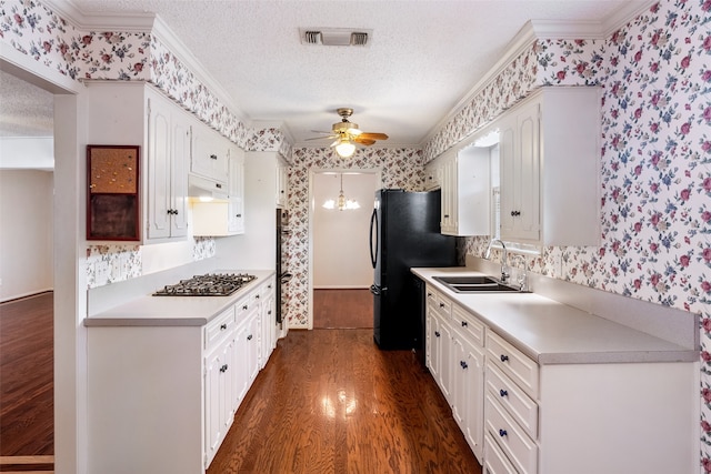 kitchen featuring ceiling fan, dark wood-type flooring, stainless steel gas stovetop, sink, and a textured ceiling