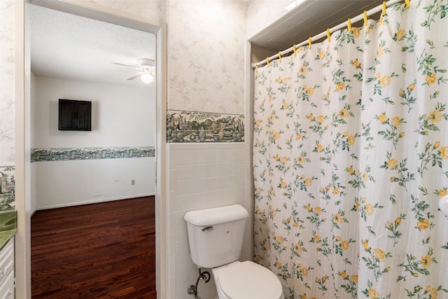 bathroom featuring a textured ceiling, tile walls, toilet, hardwood / wood-style flooring, and a shower with curtain