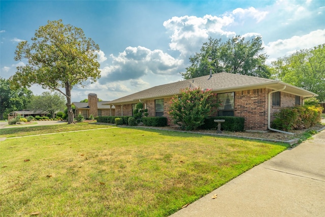 single story home featuring a front yard and brick siding