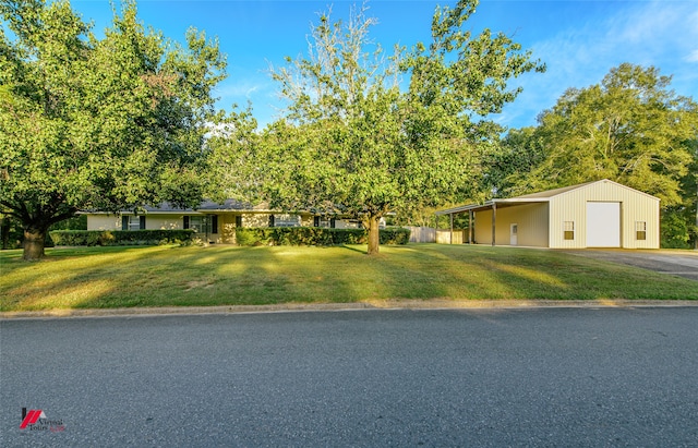 ranch-style house with a front lawn, an outdoor structure, and a garage