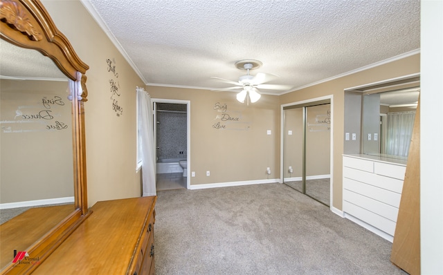 interior space featuring a closet, a textured ceiling, crown molding, carpet flooring, and ceiling fan