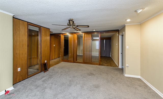 unfurnished bedroom featuring a textured ceiling, carpet floors, ceiling fan, and crown molding