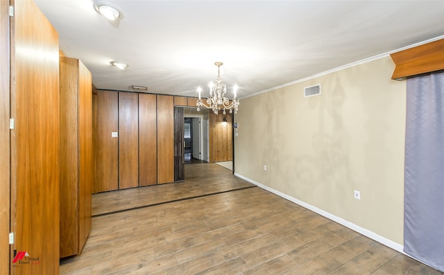 interior space featuring crown molding, light hardwood / wood-style floors, and an inviting chandelier