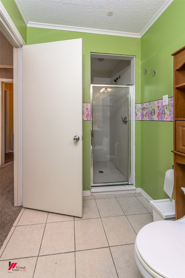 bathroom with a shower with shower door, a textured ceiling, crown molding, toilet, and tile patterned floors