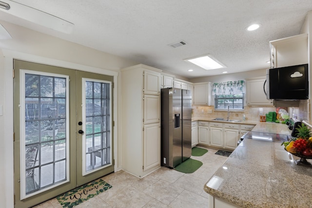 kitchen with backsplash, sink, appliances with stainless steel finishes, french doors, and light tile patterned floors