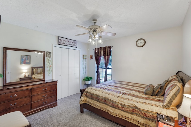 carpeted bedroom with a textured ceiling, a closet, and ceiling fan