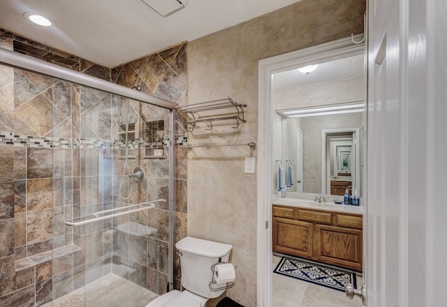 bathroom featuring toilet, vanity, tile patterned floors, tile walls, and a shower with shower door