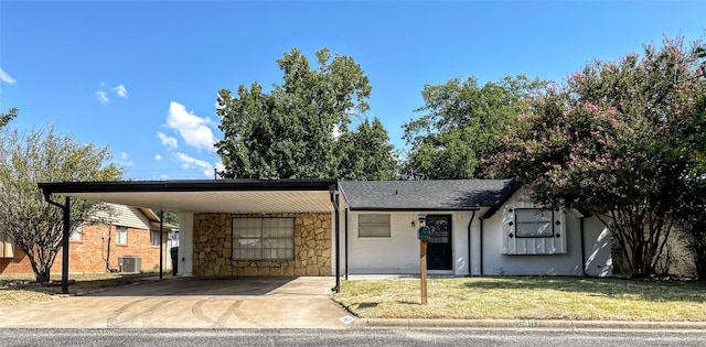 view of front of home featuring a front lawn, a carport, and central AC