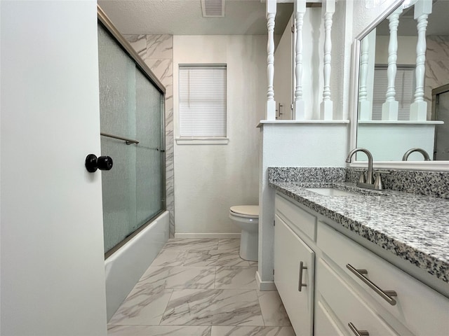 full bathroom with enclosed tub / shower combo, vanity, toilet, and a textured ceiling