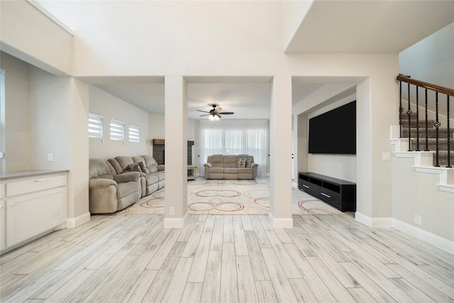 living room featuring ceiling fan and light hardwood / wood-style floors