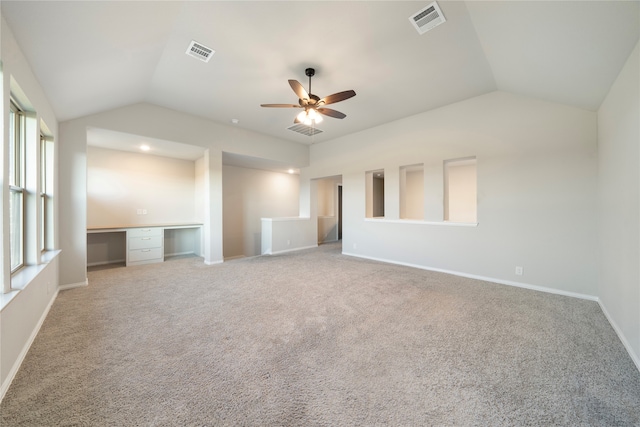 unfurnished living room featuring lofted ceiling, carpet, ceiling fan, and built in desk