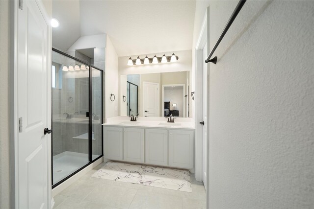 bathroom featuring vanity, lofted ceiling, and a shower with door