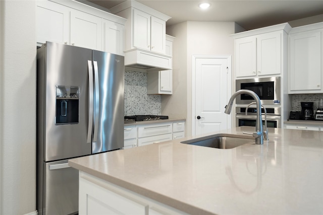 kitchen featuring sink, appliances with stainless steel finishes, white cabinetry, and tasteful backsplash