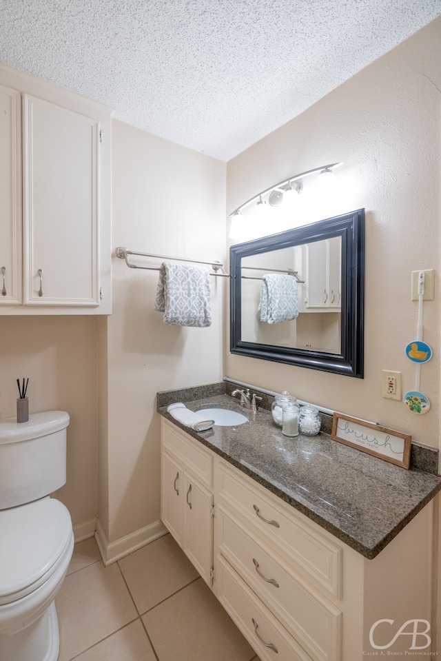 bathroom featuring vanity, tile patterned flooring, toilet, and a textured ceiling