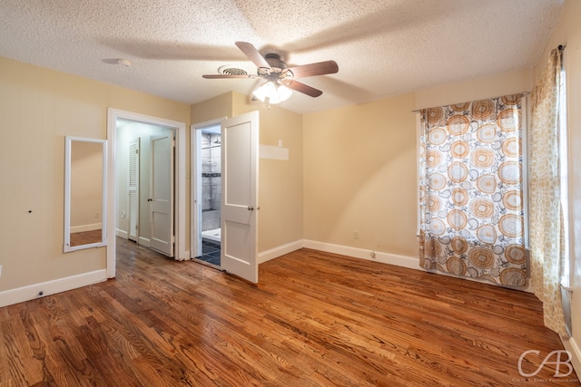 unfurnished bedroom featuring hardwood / wood-style floors, connected bathroom, a textured ceiling, and ceiling fan