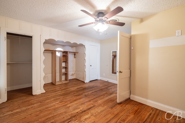 unfurnished bedroom featuring ceiling fan, hardwood / wood-style floors, and a textured ceiling