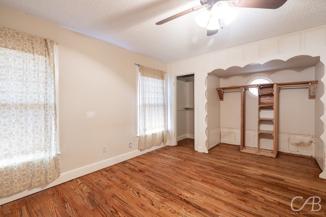 unfurnished bedroom featuring hardwood / wood-style floors, a textured ceiling, and ceiling fan