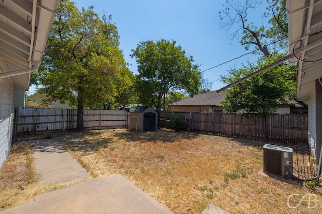 view of yard featuring central AC unit, a storage unit, and a patio area