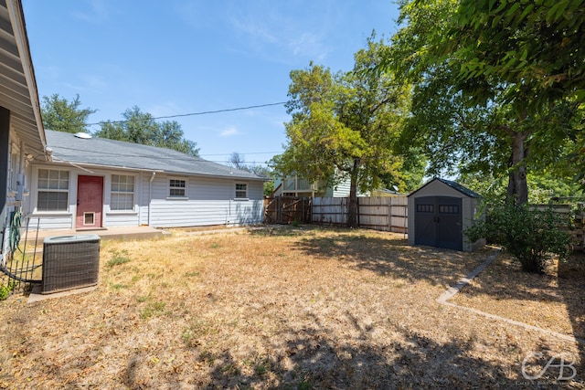 view of yard featuring a storage unit and central AC