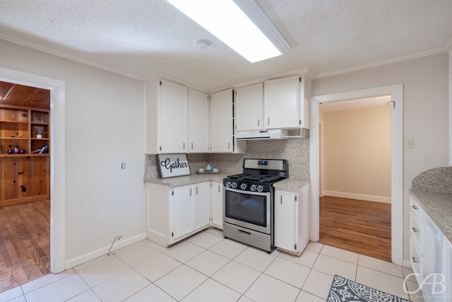 kitchen featuring white cabinets, a textured ceiling, stainless steel gas stove, backsplash, and light wood-type flooring