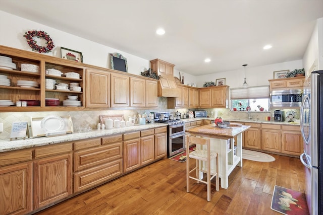 kitchen featuring tasteful backsplash, light hardwood / wood-style flooring, appliances with stainless steel finishes, and a kitchen island