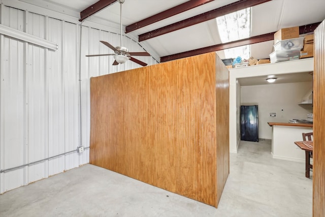 interior space with wood walls, black refrigerator, vaulted ceiling with beams, stove, and ceiling fan