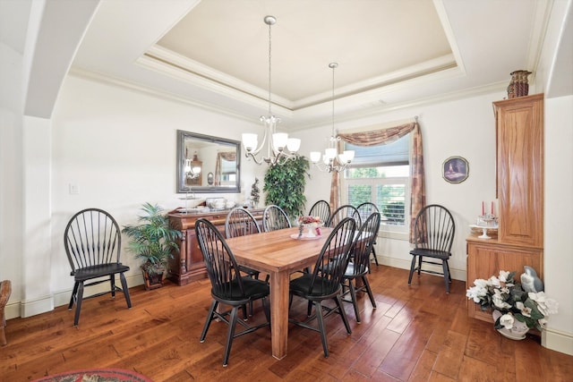 dining space featuring a tray ceiling, a notable chandelier, and dark wood-type flooring