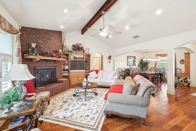 living room featuring vaulted ceiling with beams, ceiling fan, brick wall, a brick fireplace, and hardwood / wood-style flooring