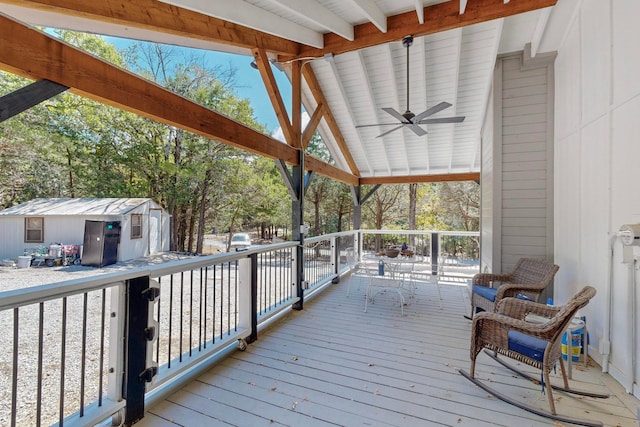 wooden terrace featuring a storage shed and ceiling fan