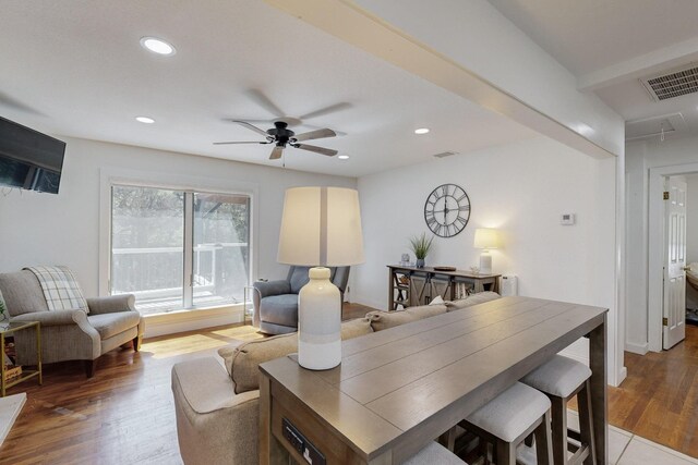 living room featuring ceiling fan, light wood-type flooring, a fireplace, and sink