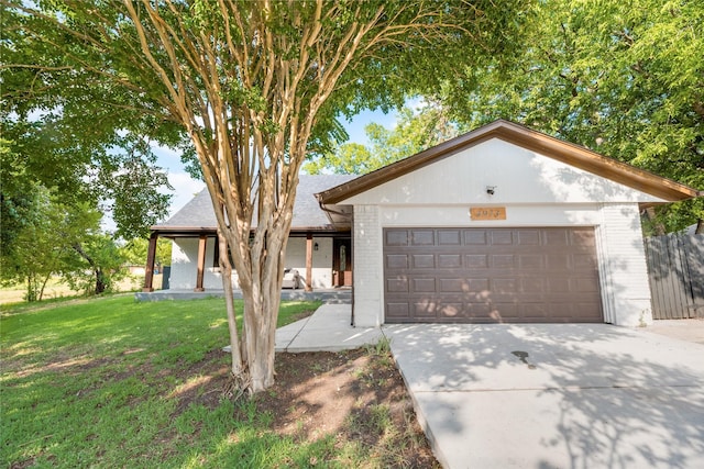 view of front of home with a front yard, brick siding, driveway, and an attached garage