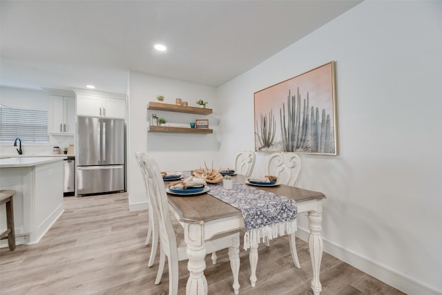 dining area featuring light wood-type flooring, baseboards, and recessed lighting