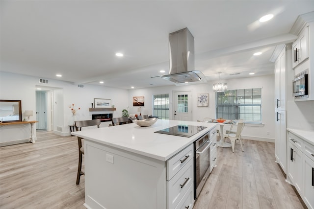 kitchen featuring a healthy amount of sunlight, a center island, white cabinets, and stainless steel appliances