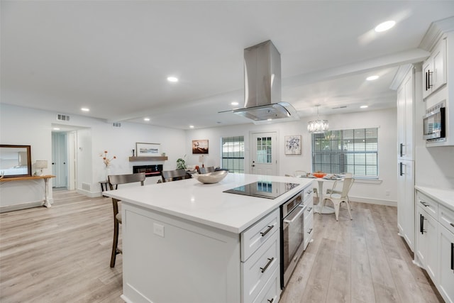 kitchen with visible vents, island exhaust hood, stainless steel appliances, light wood-type flooring, and recessed lighting