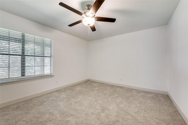 empty room featuring light carpet, ceiling fan, and baseboards