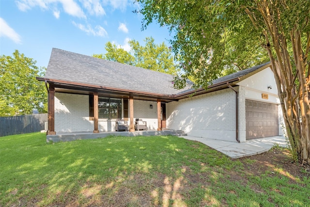 view of front of house featuring a garage, brick siding, a shingled roof, fence, and a front lawn