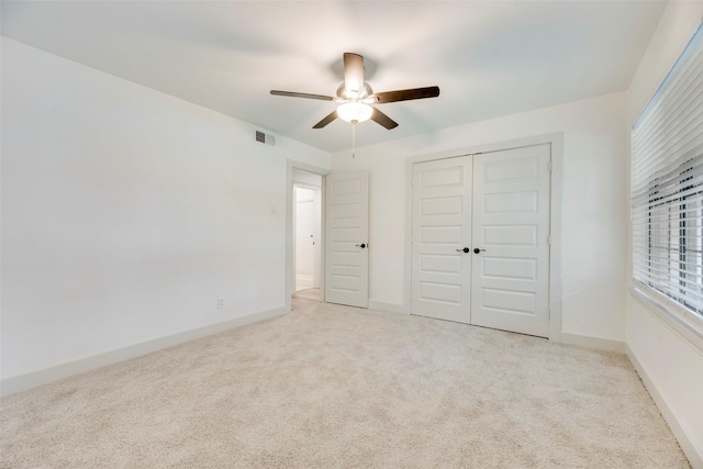 unfurnished bedroom with light carpet, a closet, and ceiling fan