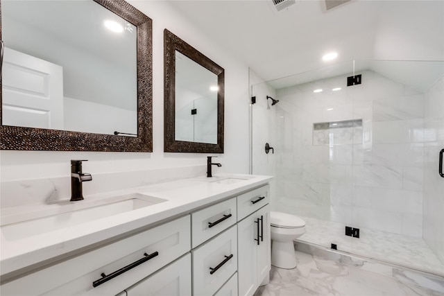 bathroom featuring vanity, a shower with shower door, and toilet