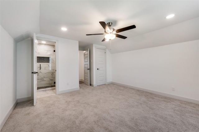 unfurnished bedroom featuring ceiling fan, light carpet, and ensuite bath