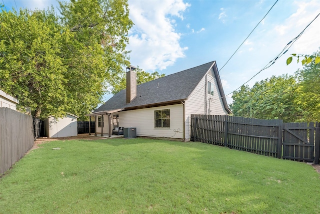 back of property featuring a shed, a yard, and central AC unit