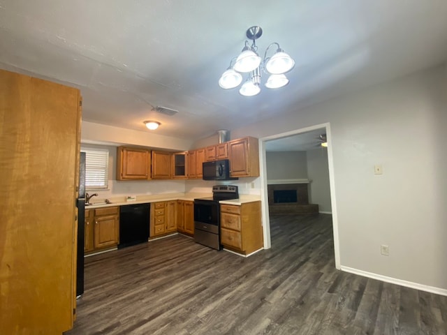 kitchen featuring sink, black appliances, dark wood-type flooring, and a chandelier