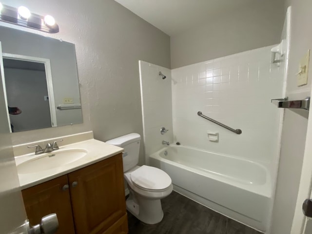 full bathroom with hardwood / wood-style flooring, vanity, shower / tub combination, and toilet