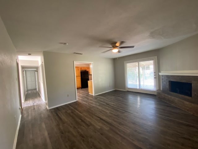 unfurnished living room with ceiling fan, dark wood-type flooring, and a fireplace