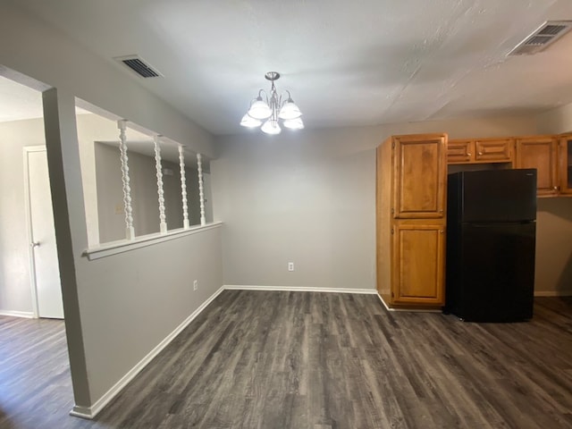 interior space featuring dark hardwood / wood-style floors, a chandelier, hanging light fixtures, and black fridge