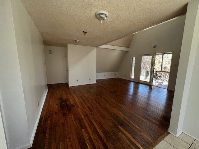 interior space with wood-type flooring, lofted ceiling, and a textured ceiling