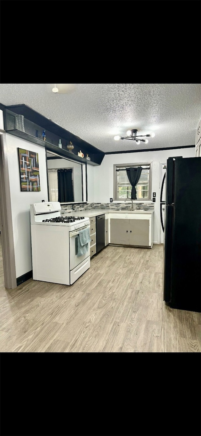 kitchen featuring black fridge, light hardwood / wood-style flooring, a textured ceiling, dishwasher, and white range with gas cooktop