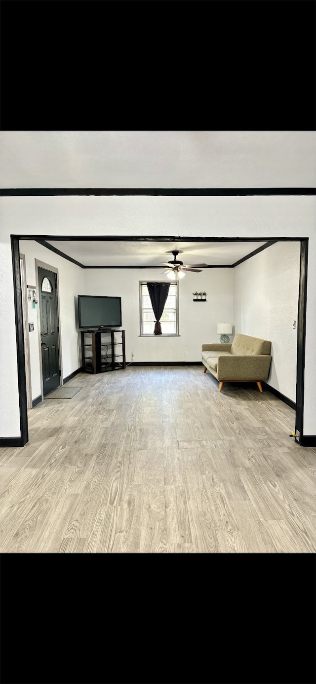 unfurnished living room featuring ceiling fan and light wood-type flooring